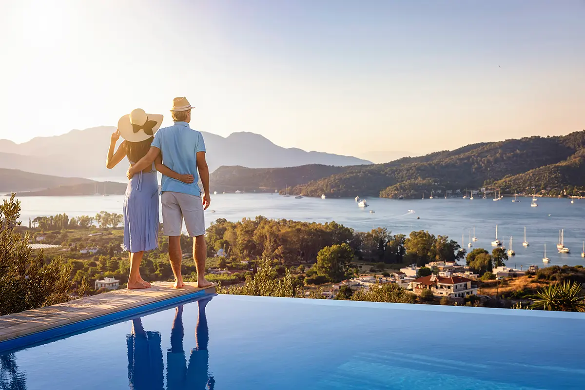 Couple looking across a coastal bay while on holiday